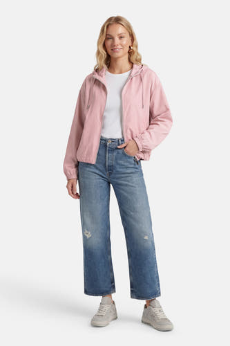 Roze jas van ONLY®, met kap, lange mouwen, rits en gedragen met een wit shirt en blauwe jeans.
