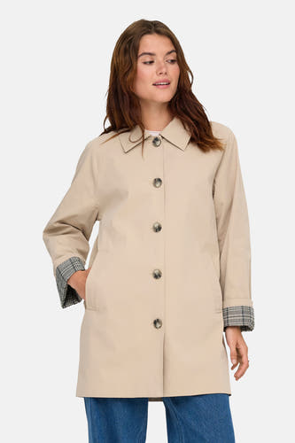 Manteau long beige ONLY avec fermeture à boutons, associé à des jeans larges et des bottines grossières.