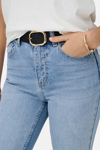Jean mom bleu clair d'ONLY, avec une ceinture noire et une boucle dorée et un bracelet doré.