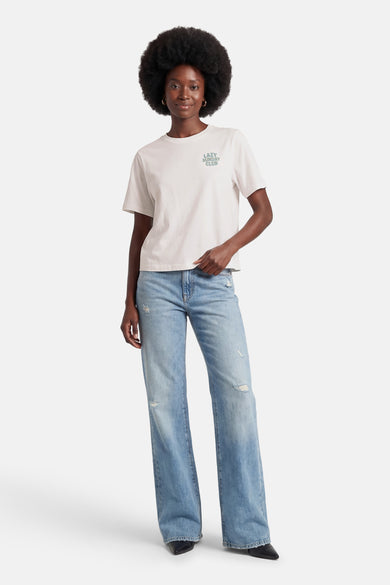 Wit T-shirt met korte mouwen van ONLY, met een kleine groene tekstprint en gecombineerd met een wijde jeans.