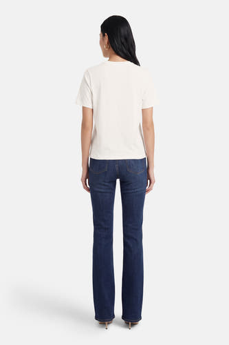 T-shirt blanc à manches courtes ONLY, vu de dos, avec jean bleu et boucles d'oreilles dorées.