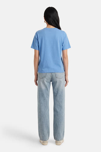 Blauw T-shirt met korte mouwen van ONLY®, met een effen kleur en losse pasvorm, op een model met jeans.