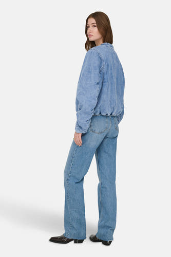 Jean en medium bleu denim de ONLY, avec des manches longues, porté avec des jeans bleus et des chaussures marrons.