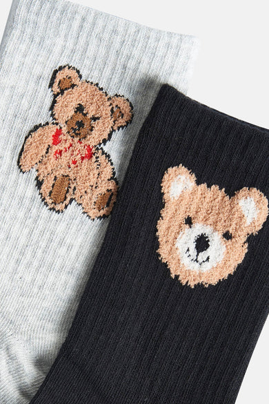 Meerkleurige sokken van ONLY® met teddybeer borduursel op een grijze en zwarte achtergrond.
