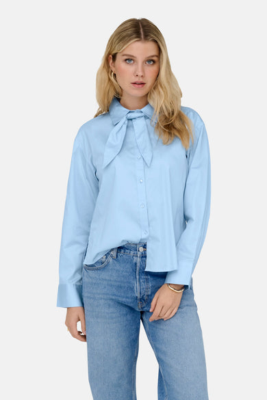 Blauw overhemd met lange mouwen van JDY, met strikdetail en gedragen met jeans.
