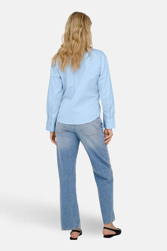 Chemise bleue à manches longues de JDY, vue de dos, combinée avec un jean et des chaussures noires.