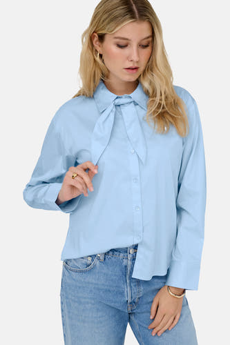 Chemise bleue à manches longues de JDY, avec fermeture à boutons et détail de nœud, combinée avec un jean.