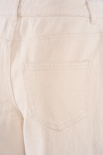 Beige gekleurde jeans van JDY, close-up van de achterkant met een enkele zak en riemlussen.
