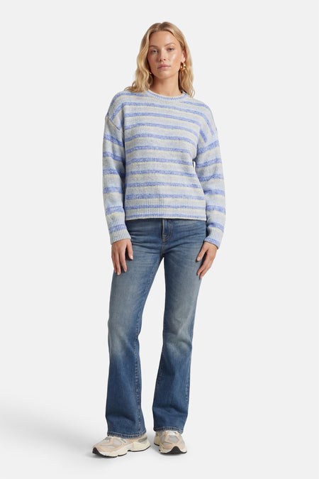 Blauwe trui met ronde hals van ONLY®, met horizontale strepen, gecombineerd met een jeans en sneakers.
