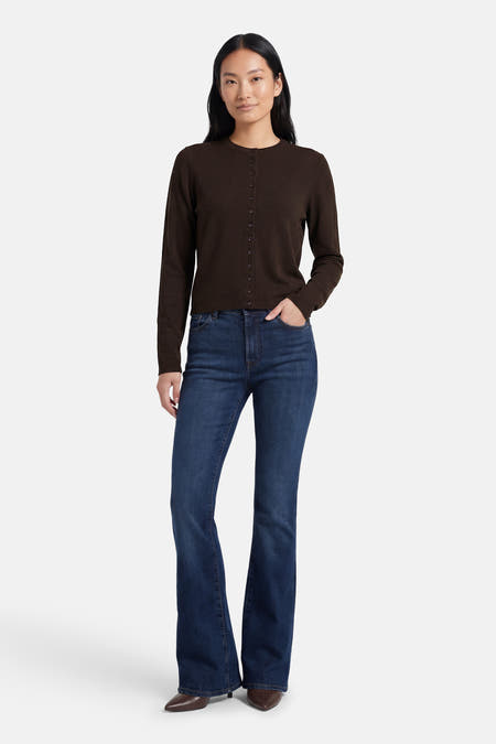 Bruine cardigan van JDY, met lange mouwen, knoopsluiting en gedragen met donkerblauwe flare jeans en bruine puntige hakken.
