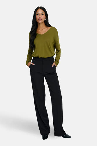Groene V-hals trui van JDY, met lange mouwen en gecombineerd met een zwarte pantalon en zwarte schoenen.