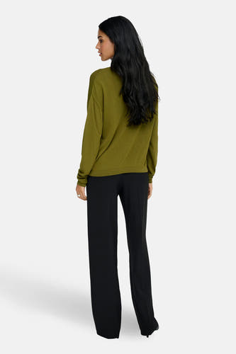 Pull vert avec col en V de JDY, à manches longues et associé à un pantalon noir.