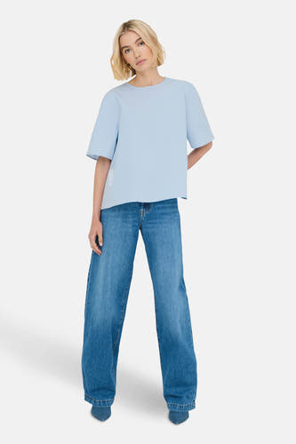 T-shirt bleu à manches courtes de ONLY, porté avec des jeans larges et des chaussures pointues.
