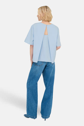T-shirt bleu à manches courtes d'ONLY, avec le dos nu et associé à des jeans larges.