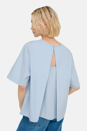 T-shirt bleu à manches courtes de ONLY, avec détail fendu sur le dos, associé à un jean.