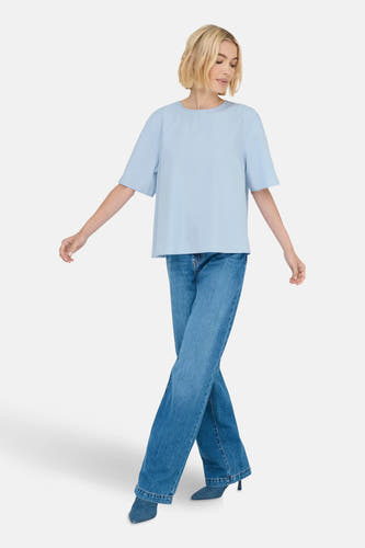 T-shirt bleu à manches courtes de ONLY, porté avec des jeans à larges poches et des escarpins bleus.
