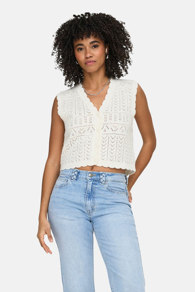 Gilet en maille ajour blanc de ONLY® avec col en V et fermeture à boutons, porté sur un jean.