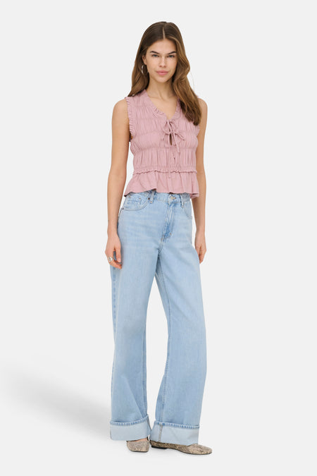 Roze mouwloze blouse van ONLY, met ruches en strikdetail aan de voorkant, gecombineerd met wijde jeans.