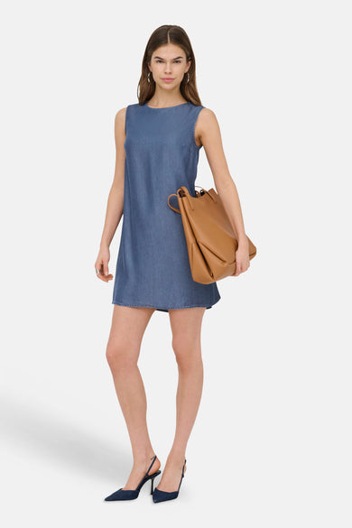 Donkerblauwe mouwloze denim jurk van ONLY® met een bruine leren tas en donkerblauwe slingback hakken.