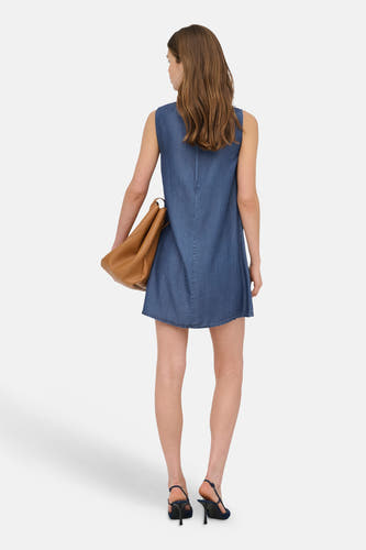 Robe sans manches en denim bleu foncé de ONLY® coupe trapèze, vue de dos, avec un sac marron et des escarpins slingback noirs.