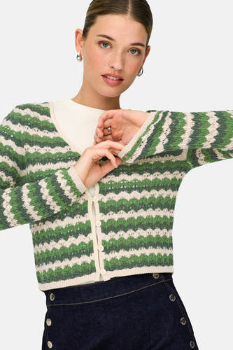 Groen vest van ONLY, met gestreept patroon en knoopsluiting, gedragen over een wit shirt en donkerblauwe rok met knopen.
