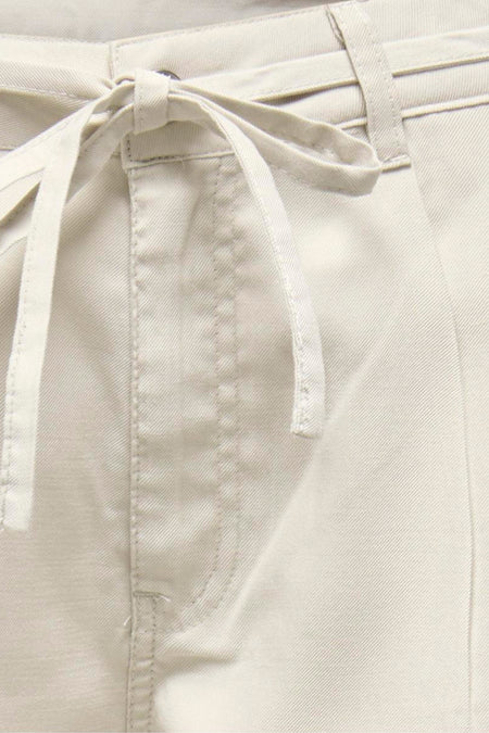 Jean de couleur écru d'ONLY, avec ceinture à nouer et poche italienne à l'avant.