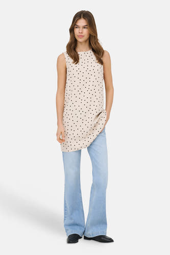 Ecru mouwloos kleedje van ONLY® met zwarte stippen, los vallend, gedragen over een jeans.