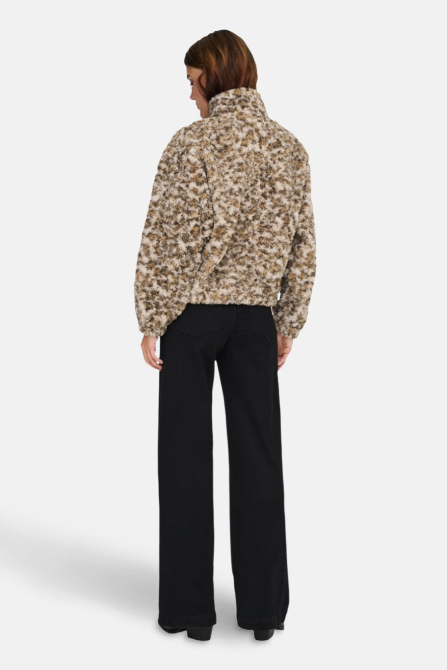 Beige korte jas van ONLY, met een bontachtige textuur en gedragen met zwarte broek.
