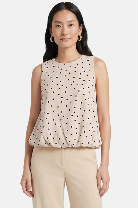 Ecru mouwloze top van ONLY® met zwarte stippen en elastische zoom, gedragen met een lichte broek.