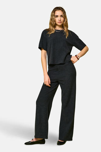 Grijze broek van ONLY, met wijde pijpen en gecombineerd met een bijpassend T-shirt en zwarte ballerina's.
