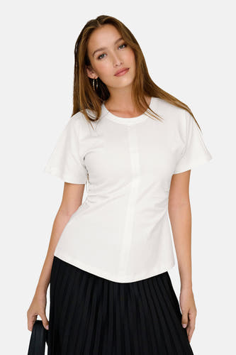 T-shirt blanc à manches courtes d'ONLY, porté avec une jupe plissée noire et des boucles d'oreilles dorées.