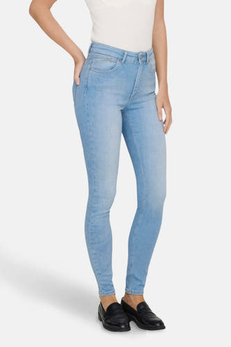 Lichtblauwe skinny jeans van ONLY, met donkere schoenen en een wit topje.
