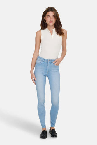 Lichtblauwe skinny jeans van ONLY, gecombineerd met een mouwloze top en zwarte schoenen.
