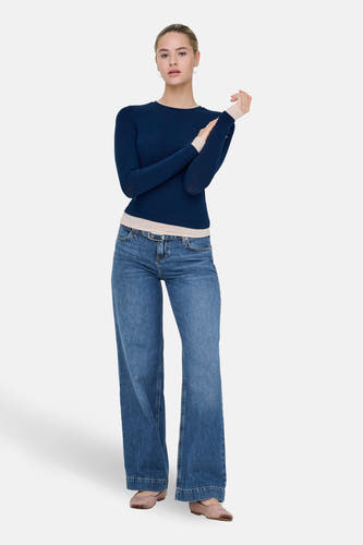 Blauw T-shirt met lange mouwen van ONLY, gedragen met een spijkerbroek met wijde pijpen en ballerina's.
