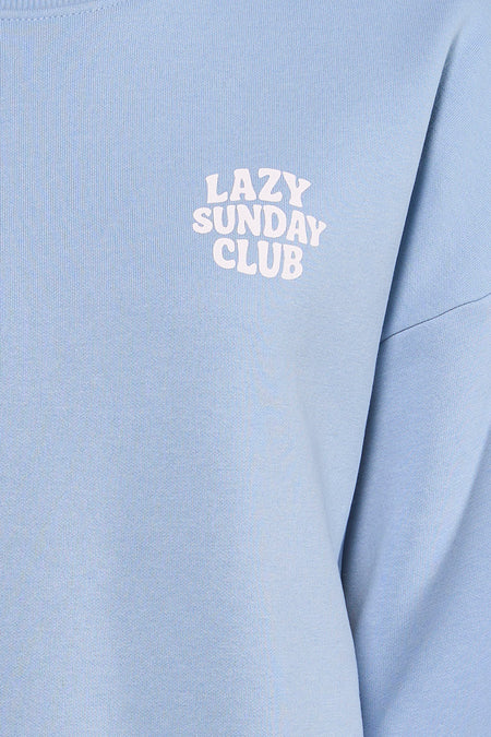 Blauwe sweater van ONLY® met de tekst "Lazy Sunday Club" erop gedrukt.