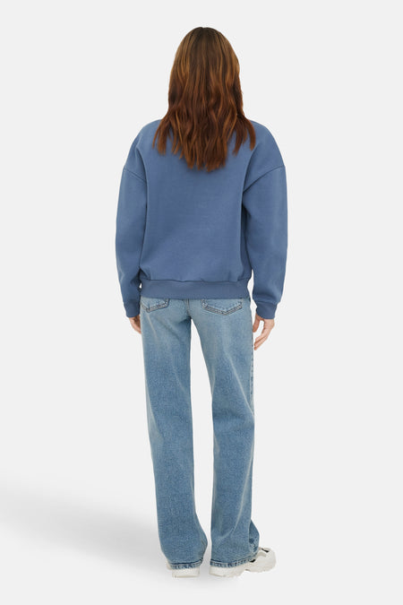 Blauwe sweater met ronde hals van ONLY, met lange mouwen, gecombineerd met een blauwe jeans.