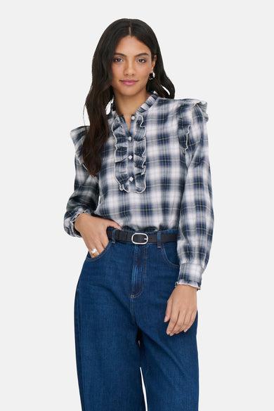 Blauw, geruite blouse avec des manches longues de ONLY, terminée par des plis et portée avec une ceinture noire et des jeans.
