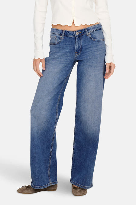 Jean wide bleu ONLY, associé à une chemise blanche et des chaussures marrons.