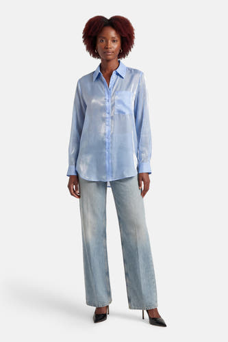 Blauw hemd met lange mouwen van ONLY®, met glanzende textuur, gedragen met wijde jeans en zwarte hakken.
