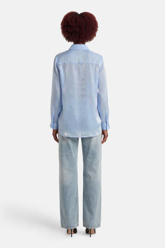Blauw hemd met lange mouwen van ONLY®, met een glanzende afwerking en gedragen met een spijkerbroek.
