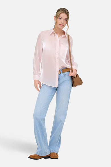 Roze hemd (lange mouwen) van ONLY®, met lange mouwen en een borstzak, gecombineerd met een bruine riem en lichtblauwe jeans.