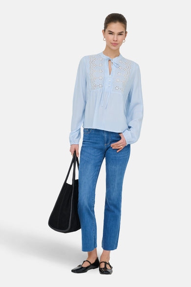 Blauwe blouse met lange mouwen van ONLY, met broderie details, gecombineerd met jeans en zwarte schoenen.