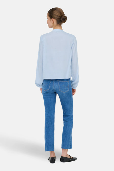 Blauw gestreepte blouse met lange mouwen van ONLY®, achterkant weergegeven, gecombineerd met jeans en platte schoenen.

