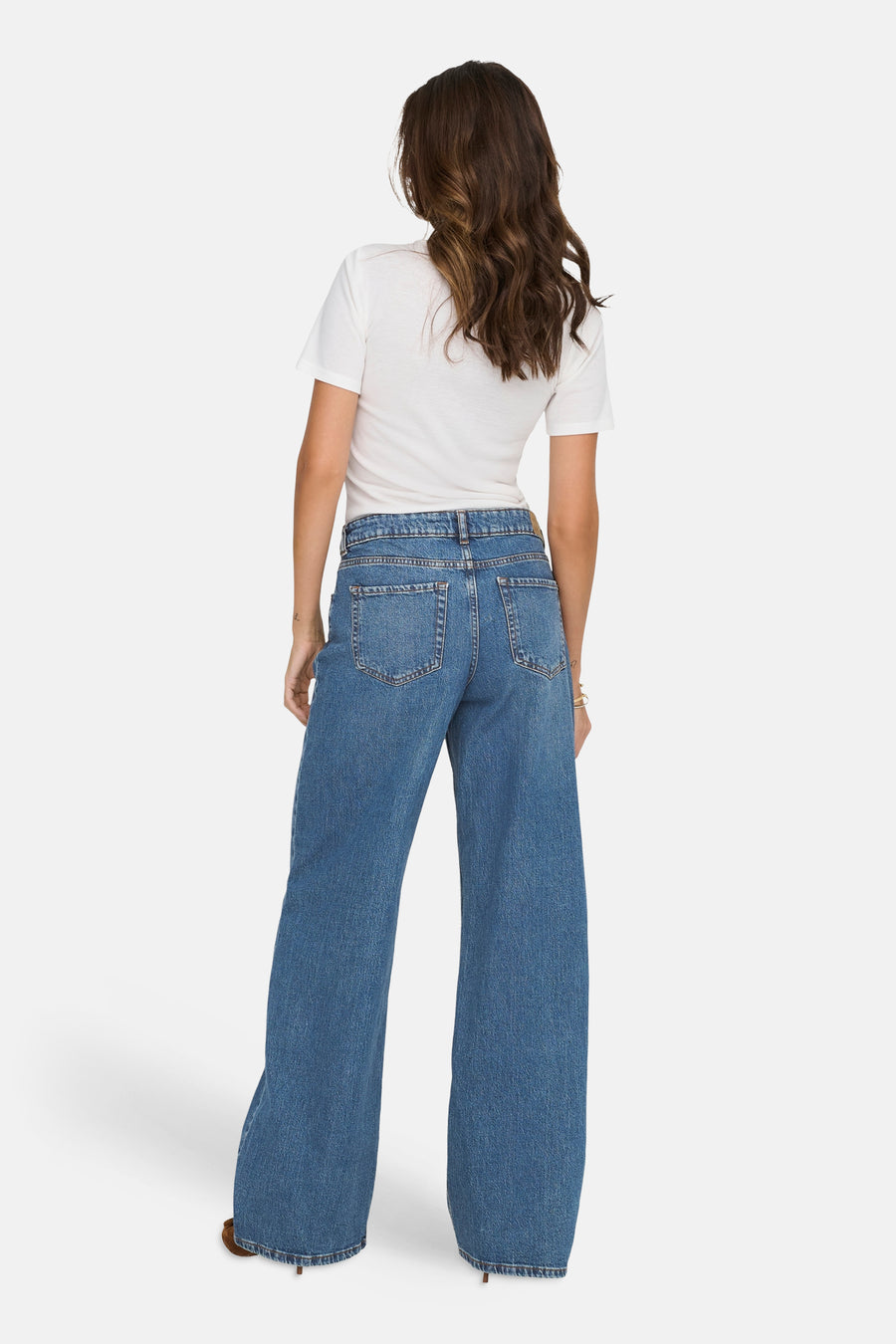 Jean large bleu moyen de JDY, vu de dos, porté avec un t-shirt blanc.