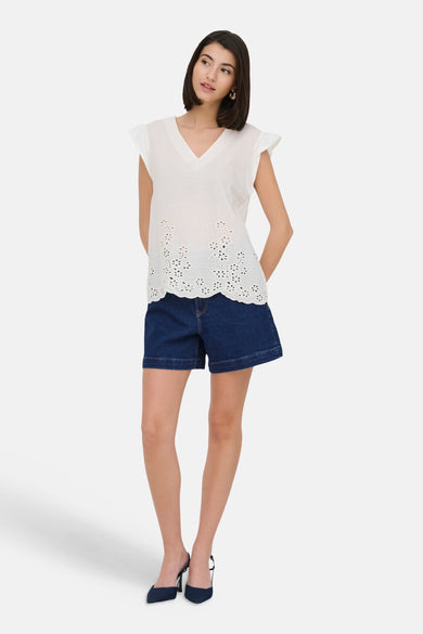 Donkerblauwe denim short van JDY, gedragen met een witte top en donkerblauwe hakken.
