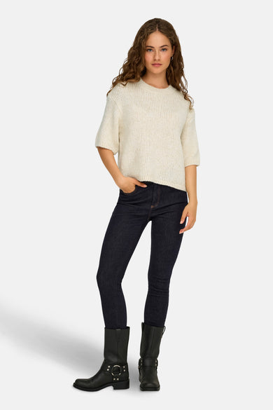 Ecru ronde hals trui van JDY, gedragen met donkere jeans en zwarte laarzen met gespen.