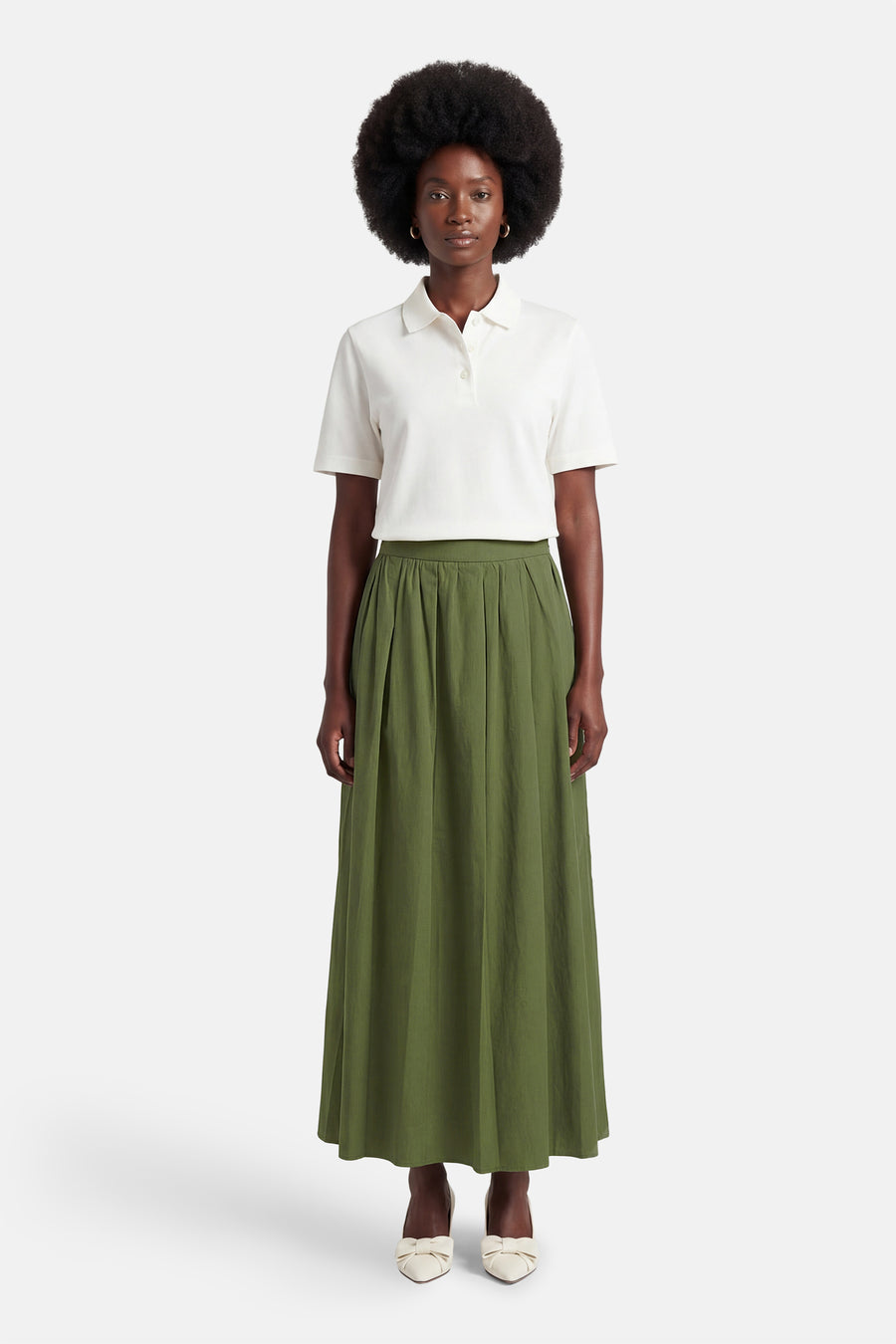 Groene rok van ONLY, met plooien en een lange lengte, gecombineerd met een witte polo en schoenen met strik.