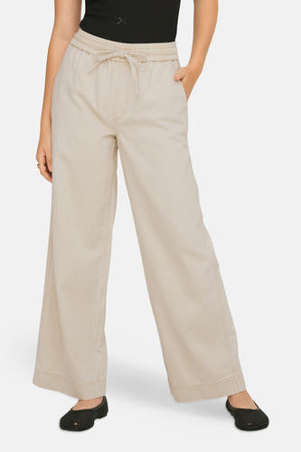 Pantalon écru de ONLY avec cordon de serrage, coupe décontractée et chaussures noires.