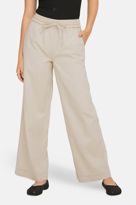 Pantalon écru de ONLY avec cordon de serrage, coupe décontractée et chaussures noires.