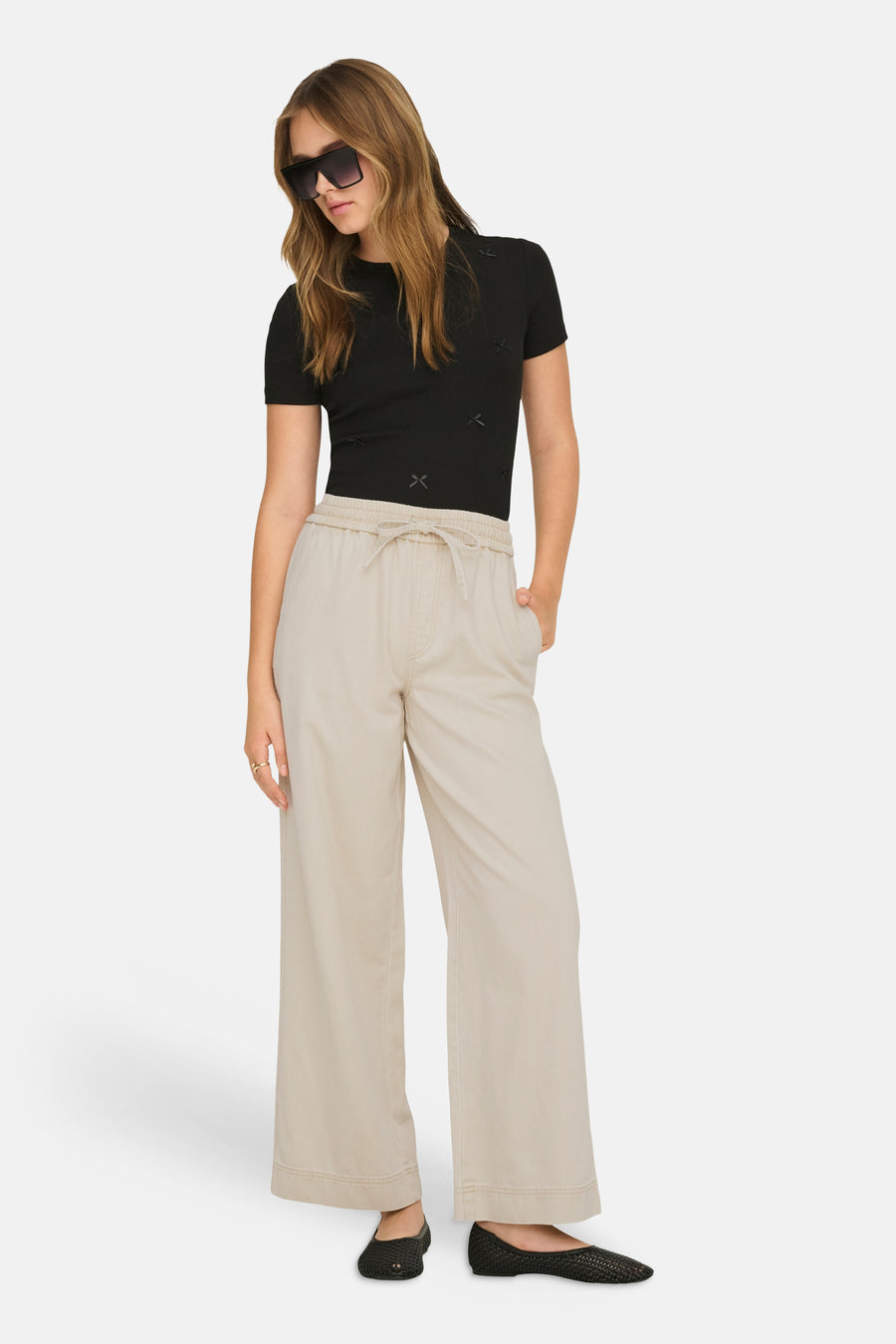 Pantalon écru de ONLY, avec une jambe large et un cordon de serrage à la taille.